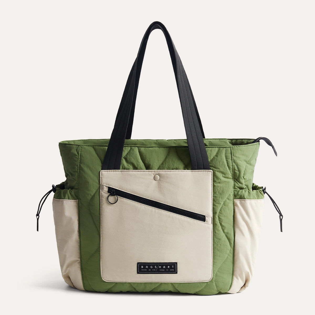Green quilted tote bag with black handles, front zip pocket, and beige side pockets, ideal for everyday use and travel.